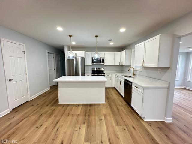 128 Ridgewood Rd, Chesapeake, VA 23325 - kitchen with appliances with stainless steel finishes, white cabinetry, a center island, light wood finished floors, and recessed lighting