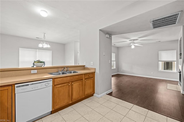 408 Coastal Walk Pl Unit 102, Virginia Beach, VA 23451 - kitchen with white dishwasher, a sink, brown cabinets, a chandelier, and light countertops