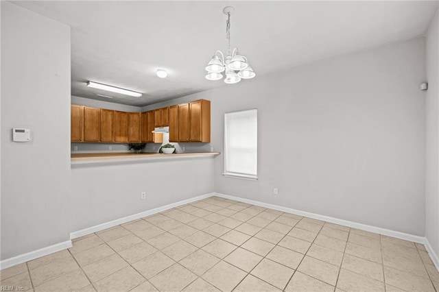408 Coastal Walk Pl Unit 102, Virginia Beach, VA 23451 - kitchen featuring a chandelier, light countertops, decorative light fixtures, under cabinet range hood, and baseboards