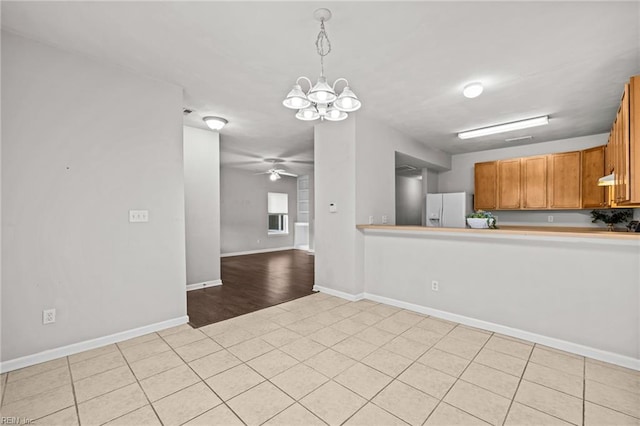 408 Coastal Walk Pl Unit 102, Virginia Beach, VA 23451 - kitchen featuring white refrigerator with ice dispenser, a chandelier, baseboards, brown cabinets, and hanging light fixtures