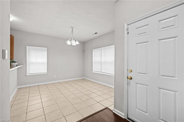 408 Coastal Walk Pl Unit 102, Virginia Beach, VA 23451 - unfurnished dining area featuring a chandelier, baseboards, and tile patterned flooring