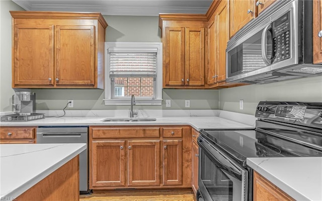 106 Edith Wharton Sq, Newport News, VA 23606 - kitchen with stainless steel appliances, a sink, ornamental molding, brown cabinets, and light stone countertops