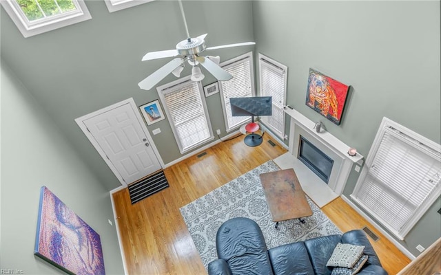 106 Edith Wharton Sq, Newport News, VA 23606 - living area with ceiling fan, wood finished floors, a fireplace with flush hearth, and a towering ceiling