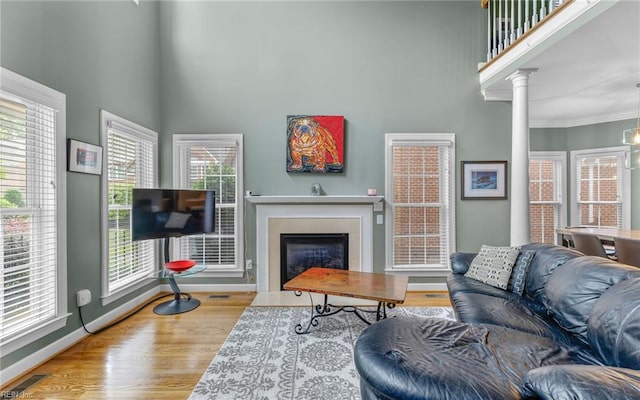 106 Edith Wharton Sq, Newport News, VA 23606 - living area with a fireplace with flush hearth, a towering ceiling, baseboards, wood finished floors, and crown molding