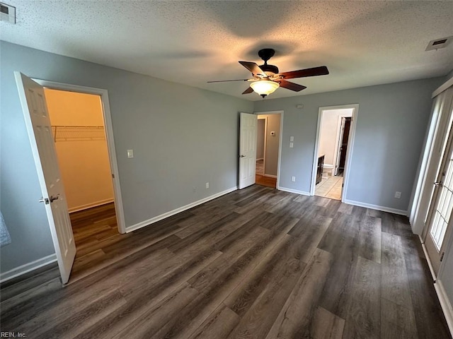 2304 Londale Ct, Virginia Beach, VA 23456 - unfurnished bedroom with dark wood-style floors, a textured ceiling, baseboards, a walk in closet, and a closet