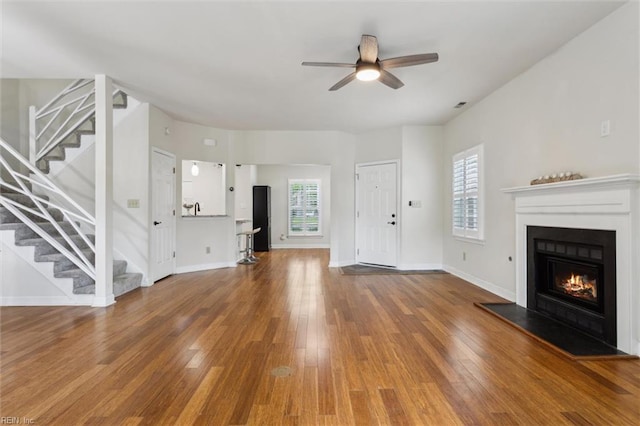 947 Willow Pt, Newport News, VA 23602 - unfurnished living room featuring stairs, ceiling fan, a glass covered fireplace, wood finished floors, and baseboards