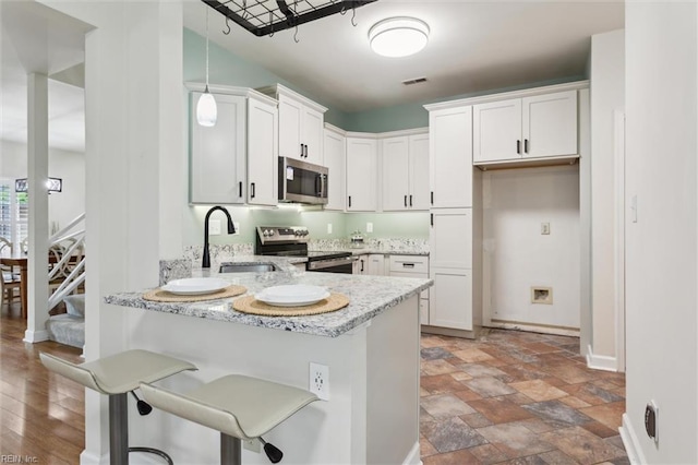 947 Willow Pt, Newport News, VA 23602 - kitchen with appliances with stainless steel finishes, a sink, a peninsula, light stone countertops, and pendant lighting