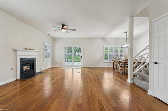 947 Willow Pt, Newport News, VA 23602 - unfurnished living room featuring ceiling fan, stairs, wood-type flooring, a glass covered fireplace, and baseboards