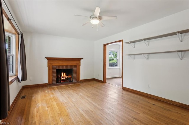 702 Blair Ave, Hampton, VA 23661 - unfurnished living room featuring light wood-type flooring, ceiling fan, a brick fireplace, and baseboards