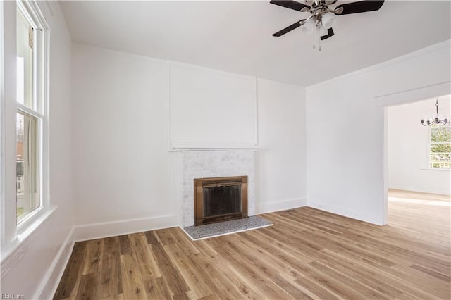 3711 Abingdon Cir, Norfolk, VA 23513 - unfurnished living room with a ceiling fan, a brick fireplace, light wood-type flooring, a chandelier, and baseboards