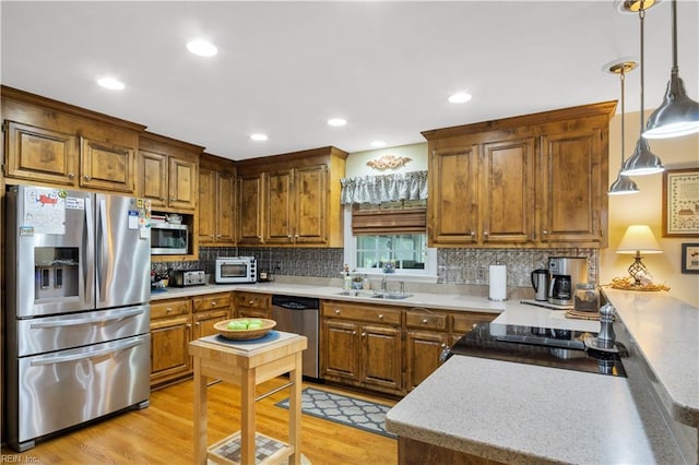 210 John Pott Dr, Williamsburg, VA 23188 - kitchen featuring stainless steel appliances, a sink, backsplash, light wood-style floors, and brown cabinets