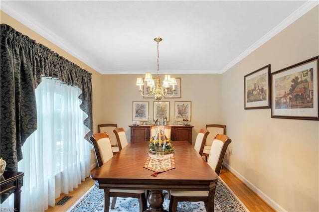 210 John Pott Dr, Williamsburg, VA 23188 - dining room with light wood finished floors, a chandelier, crown molding, and baseboards