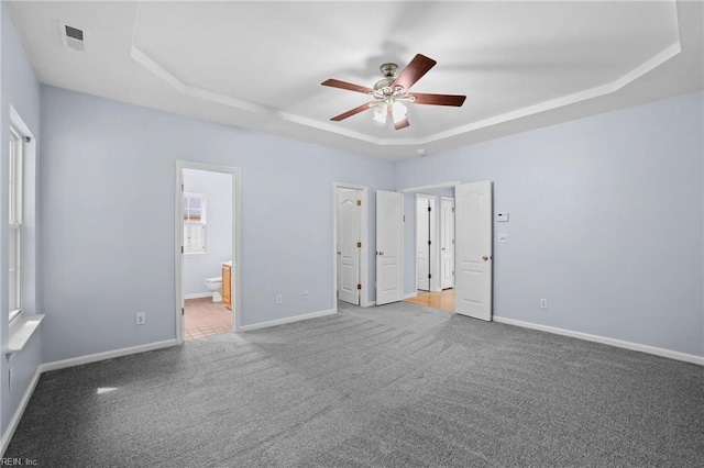 2110 King St, Suffolk, VA 23434 - unfurnished bedroom featuring a raised ceiling, carpet floors, baseboards, and ensuite bathroom