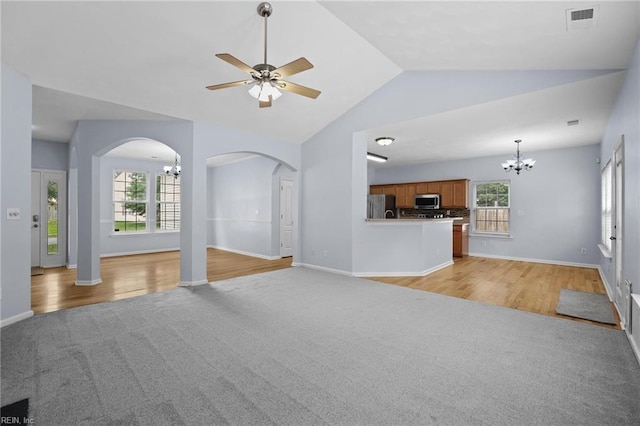 2110 King St, Suffolk, VA 23434 - unfurnished living room featuring a chandelier, light colored carpet, arched walkways, lofted ceiling, and ceiling fan