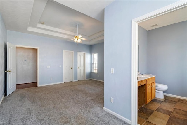 310 Lighthouse Way, Carrollton, VA 23314 - unfurnished bedroom with a tray ceiling, ensuite bath, baseboards, and a ceiling fan