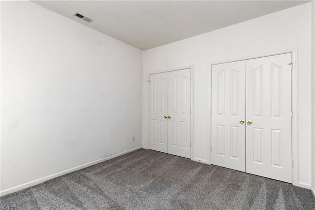 310 Lighthouse Way, Carrollton, VA 23314 - unfurnished bedroom featuring two closets, carpet flooring, and baseboards