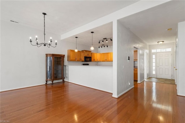 310 Lighthouse Way, Carrollton, VA 23314 - kitchen featuring black microwave, a chandelier, wood finished floors, track lighting, and light countertops