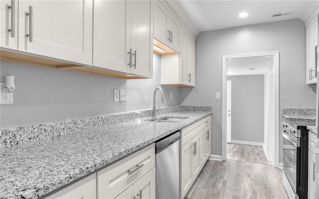 3506 Somme Ave, Norfolk, VA 23509 - kitchen with appliances with stainless steel finishes, a sink, light wood-type flooring, light stone countertops, and white cabinets