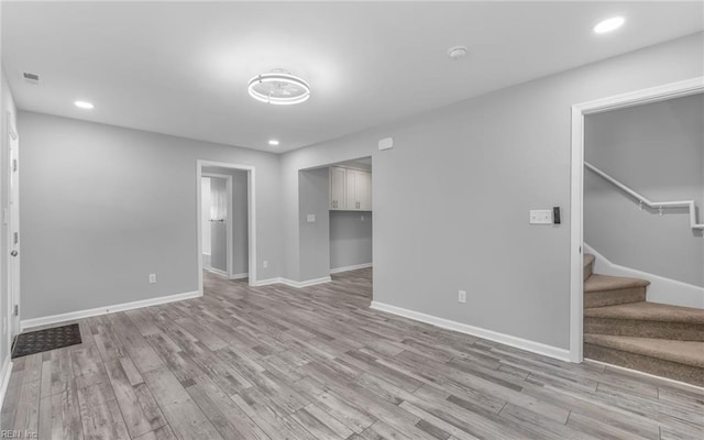 3506 Somme Ave, Norfolk, VA 23509 - unfurnished living room with light wood finished floors, stairway, baseboards, and recessed lighting