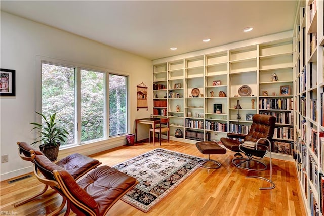 140 Hearthside Ln, Williamsburg, VA 23185 - sitting room featuring wood finished floors, baseboards, recessed lighting, and wall of books