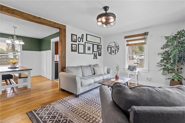 6615 Cabot Ave, Norfolk, VA 23502 - living room featuring a chandelier, light wood finished floors, and a wainscoted wall