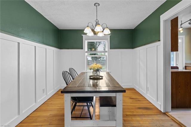 6615 Cabot Ave, Norfolk, VA 23502 - dining room featuring a decorative wall, a chandelier, a textured ceiling, wainscoting, and wood finished floors