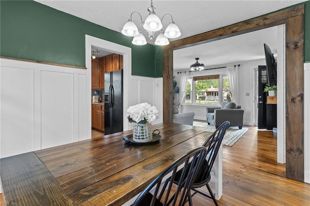 6615 Cabot Ave, Norfolk, VA 23502 - dining space featuring a chandelier, a decorative wall, light wood finished floors, and a wainscoted wall