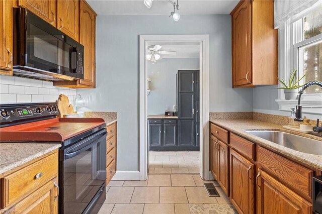 6615 Cabot Ave, Norfolk, VA 23502 - kitchen with black appliances, a sink, light tile patterned flooring, light countertops, and backsplash