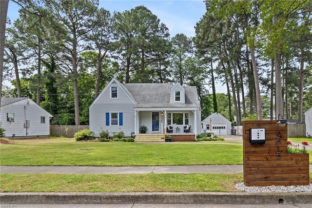 6615 Cabot Ave, Norfolk, VA 23502 - cape cod home featuring a porch, an outbuilding, a detached garage, and view of scattered trees