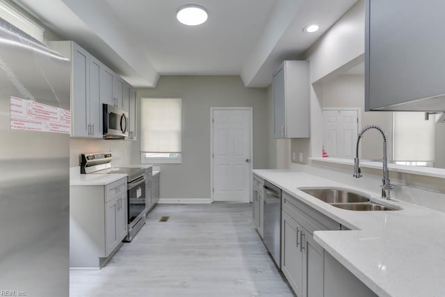 814 E 26th St, Norfolk, VA 23504 - kitchen with stainless steel appliances, a sink, baseboards, light wood-style floors, and gray cabinets