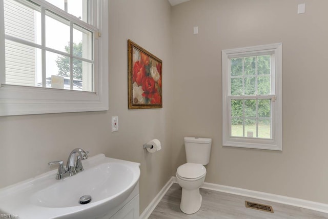 814 E 26th St, Norfolk, VA 23504 - half bathroom featuring a sink, toilet, baseboards, and wood finished floors