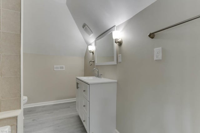 814 E 26th St, Norfolk, VA 23504 - bathroom featuring vanity, toilet, wood finished floors, lofted ceiling, and baseboards