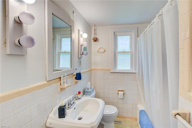 9206 Dixon Rd, Suffolk, VA 23433 - bathroom with tile walls, a sink, toilet, a wainscoted wall, and shower / tub combo with curtain