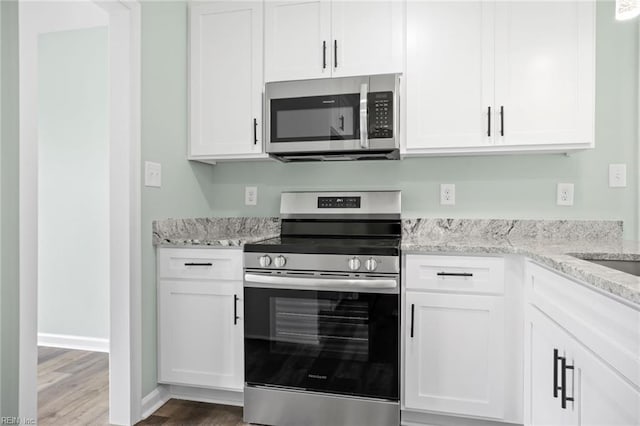 2915 Berkley Ave, Chesapeake, VA 23325 - kitchen featuring appliances with stainless steel finishes, wood finished floors, white cabinets, and light stone counters