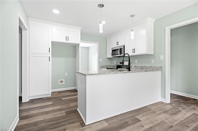2915 Berkley Ave, Chesapeake, VA 23325 - kitchen with appliances with stainless steel finishes, white cabinetry, wood finished floors, light stone countertops, and a peninsula