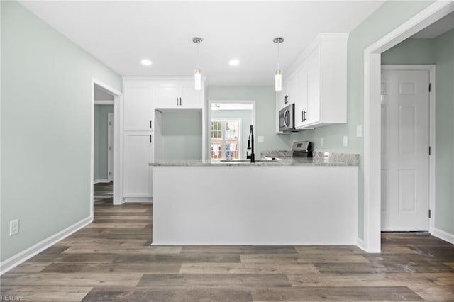 2915 Berkley Ave, Chesapeake, VA 23325 - kitchen featuring stove, stainless steel microwave, white cabinetry, a peninsula, and light stone counters
