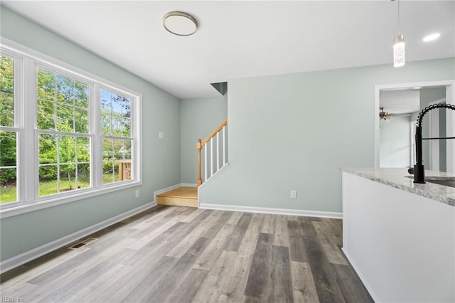 2915 Berkley Ave, Chesapeake, VA 23325 - unfurnished living room with stairway, wood finished floors, baseboards, and a sink