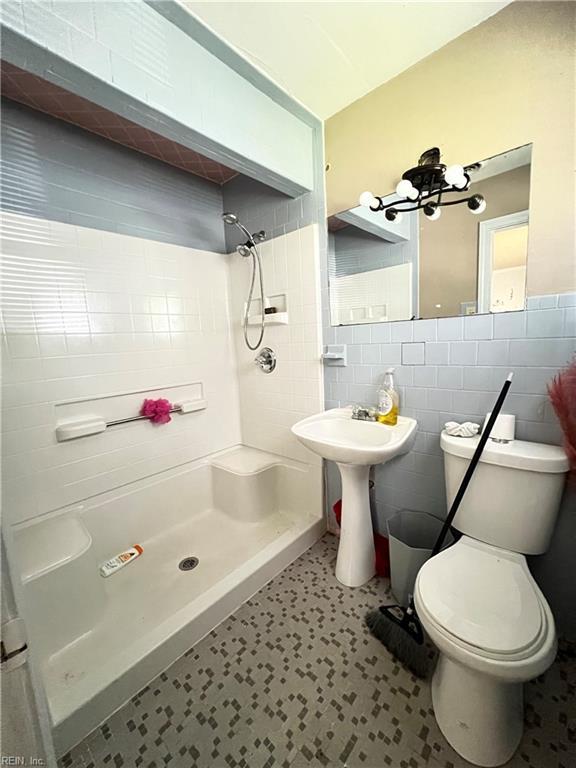 418 Fox Hill Rd, Hampton, VA 23669 - full bathroom featuring a shower stall, tile walls, toilet, a chandelier, and tile patterned floors