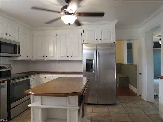 21139 Reynolds Dr, Carrollton, VA 23314 - kitchen with stainless steel appliances, ceiling fan, white cabinets, light tile patterned flooring, and ornamental molding