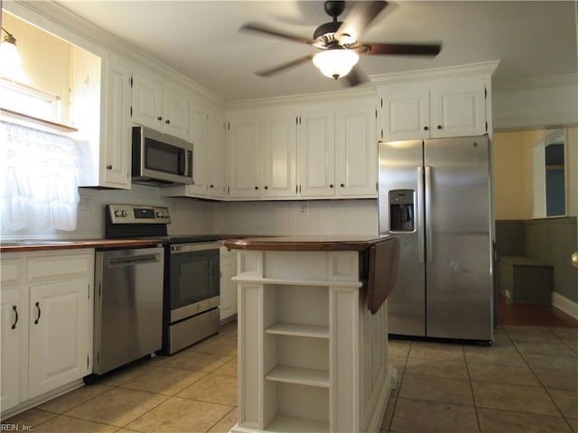 21139 Reynolds Dr, Carrollton, VA 23314 - kitchen with appliances with stainless steel finishes, light tile patterned floors, white cabinetry, ceiling fan, and ornamental molding