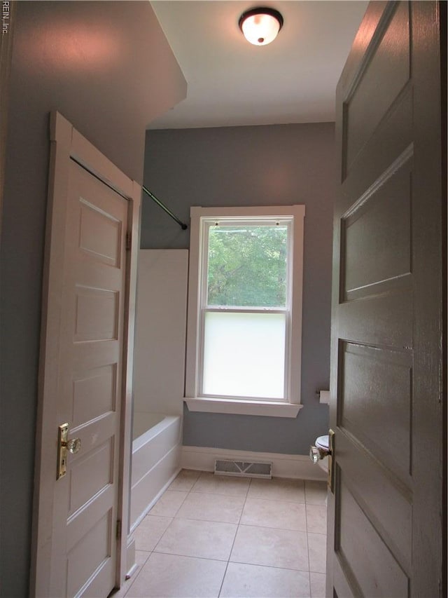 21139 Reynolds Dr, Carrollton, VA 23314 - bathroom featuring tile patterned floors, tub / shower combination, and baseboards