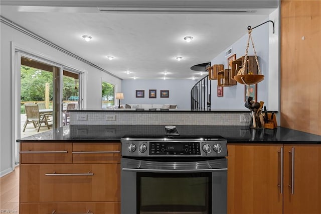5409 Challedon Dr, Virginia Beach, VA 23462 - kitchen with stainless steel range with electric stovetop, brown cabinetry, light wood finished floors, dark stone counters, and modern cabinets