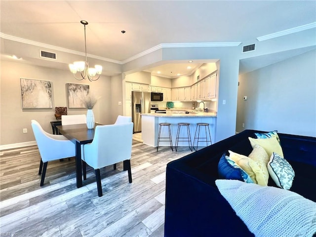 30 Brough Ln # 301, Hampton, VA 23669 - dining room with a chandelier, light wood-style flooring, ornamental molding, and baseboards