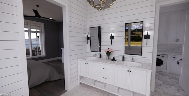 814 Calthrop Neck Rd, Yorktown, VA 23693 - bathroom with washer / clothes dryer, double vanity, wooden walls, and a chandelier