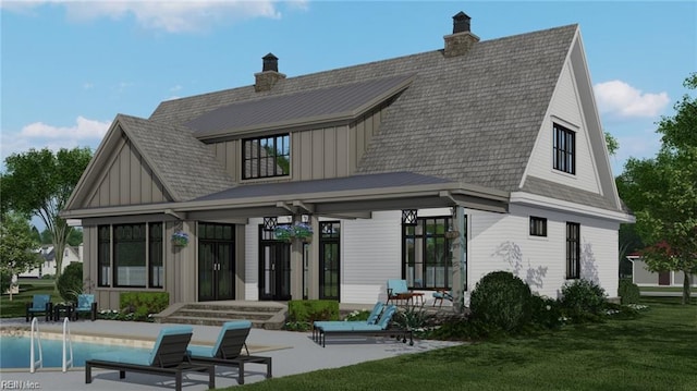 814 Calthrop Neck Rd, Yorktown, VA 23693 - rear view of house featuring board and batten siding, a yard, a patio area, an outdoor pool, and a chimney