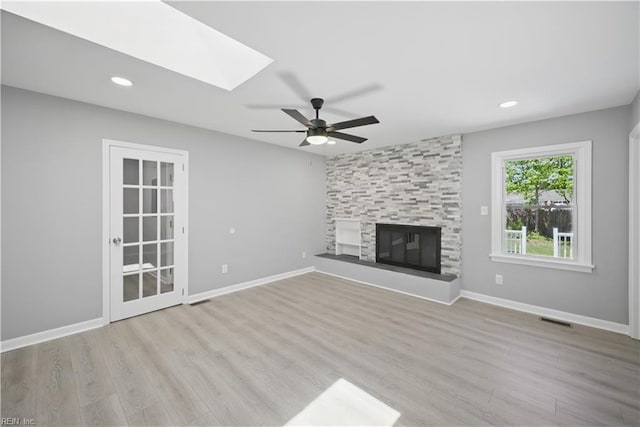 808 Williams Ave, Chesapeake, VA 23323 - unfurnished living room with ceiling fan, a skylight, wood finished floors, a tile fireplace, and baseboards
