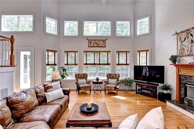 2081 Harpers Ml, Williamsburg, VA 23185 - living area featuring a towering ceiling, a premium fireplace, healthy amount of natural light, wood finished floors, and crown molding