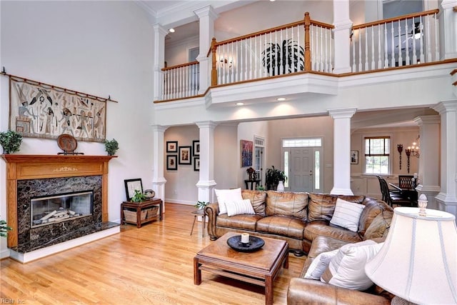 2081 Harpers Ml, Williamsburg, VA 23185 - living room featuring a fireplace, wood finished floors, crown molding, ornate columns, and a high ceiling