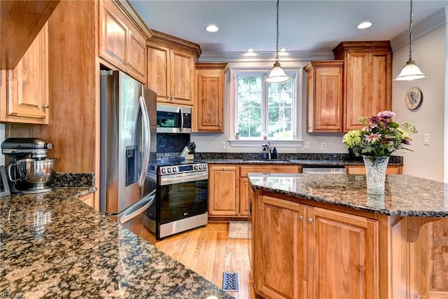 2081 Harpers Ml, Williamsburg, VA 23185 - kitchen with appliances with stainless steel finishes, a sink, crown molding, light wood-style floors, and brown cabinetry
