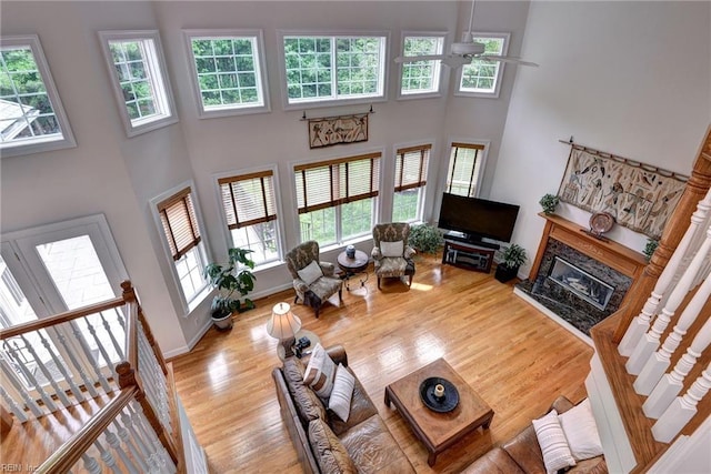 2081 Harpers Ml, Williamsburg, VA 23185 - living room with ceiling fan, plenty of natural light, a towering ceiling, wood finished floors, and a premium fireplace